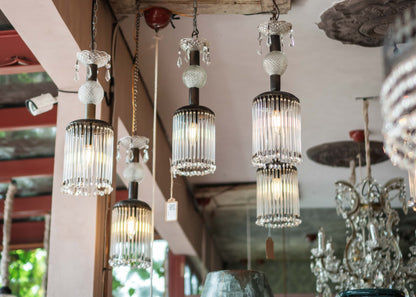 Vintage-style chandeliers hanging from a ceiling with a rustic wooden fixture.